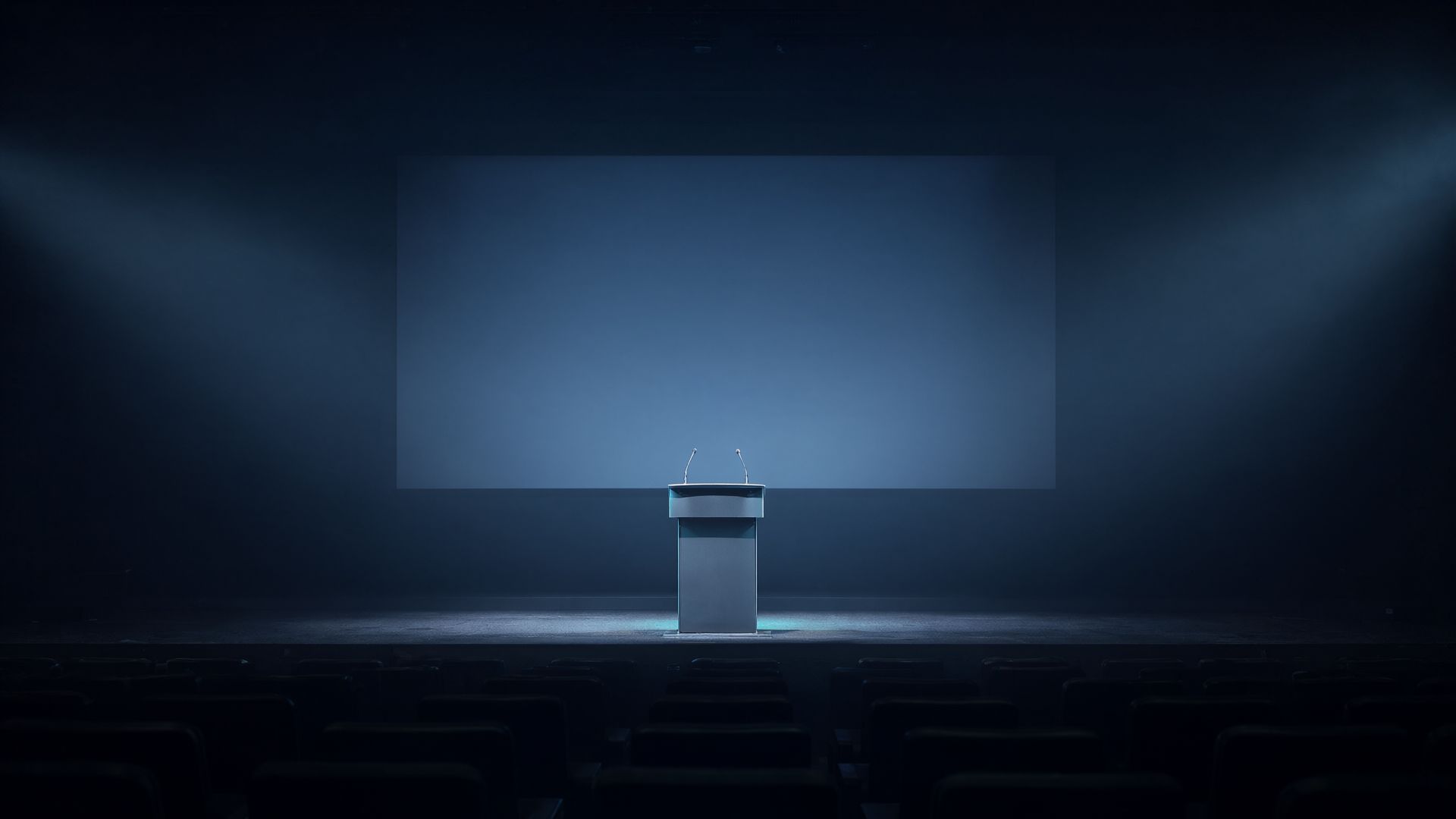 An empty conference stage with a lectern under a spotlight