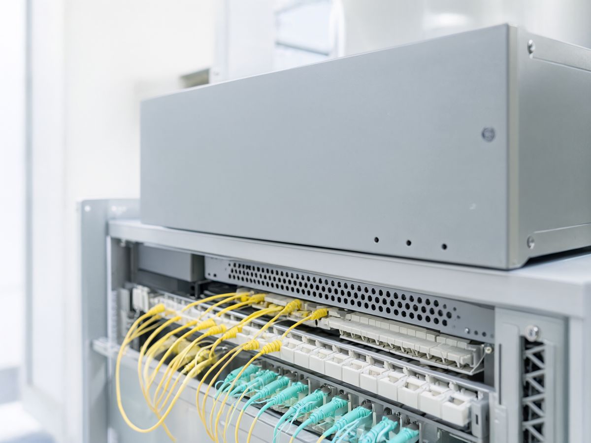 A small rack appliance with a fan grille above a fibre patch panel with yellow and aqua fibre