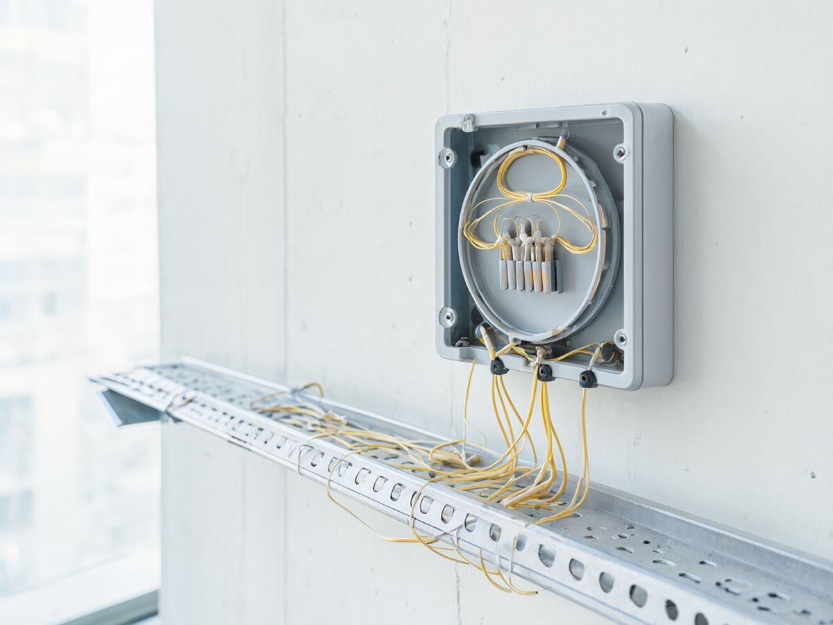 A small wall-mounted fibre distribution box in an office building riser